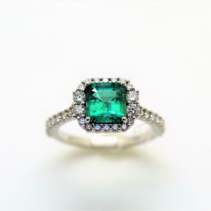 cocktail ring with an emerald and halo of diamonds