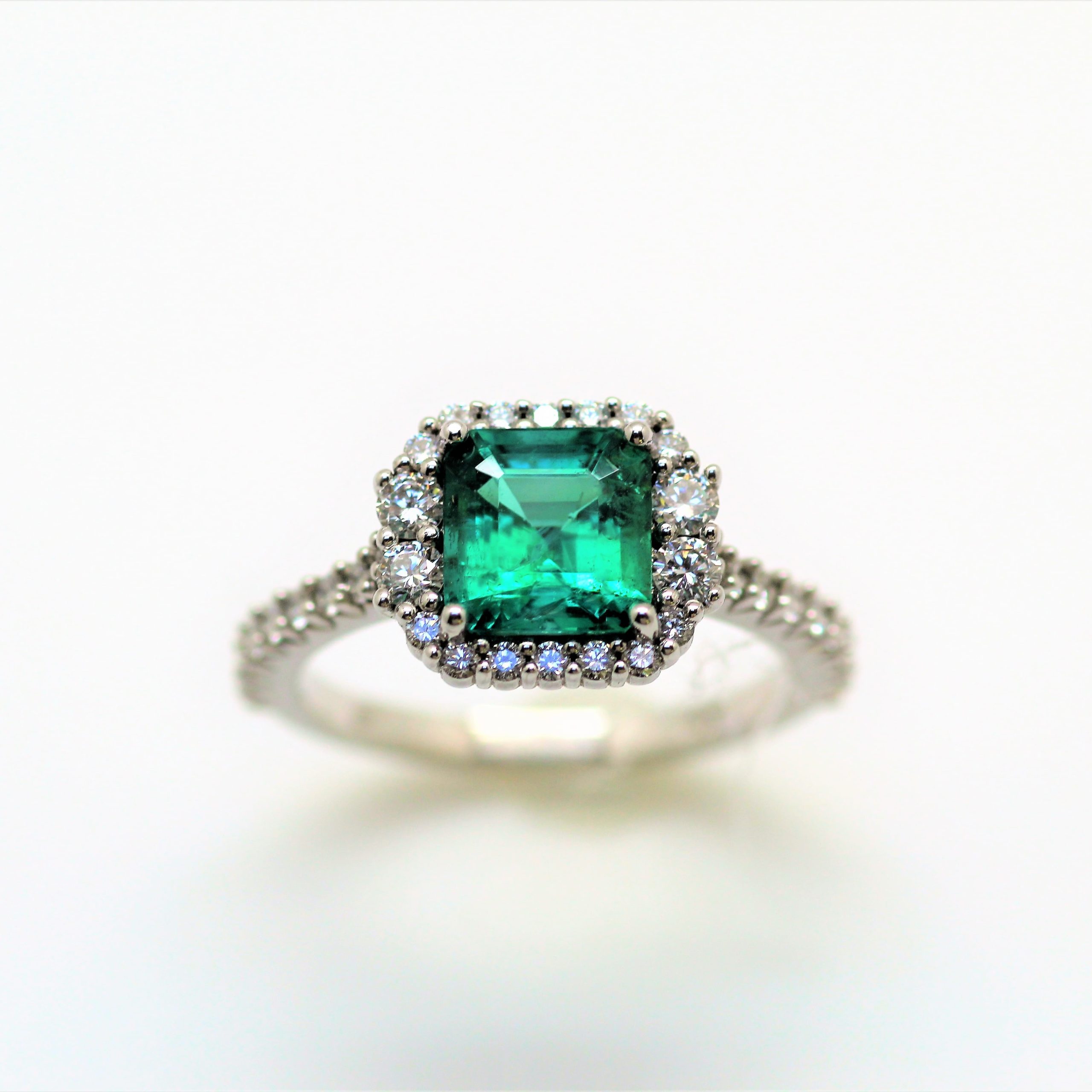 cocktail ring with an emerald and halo of diamonds